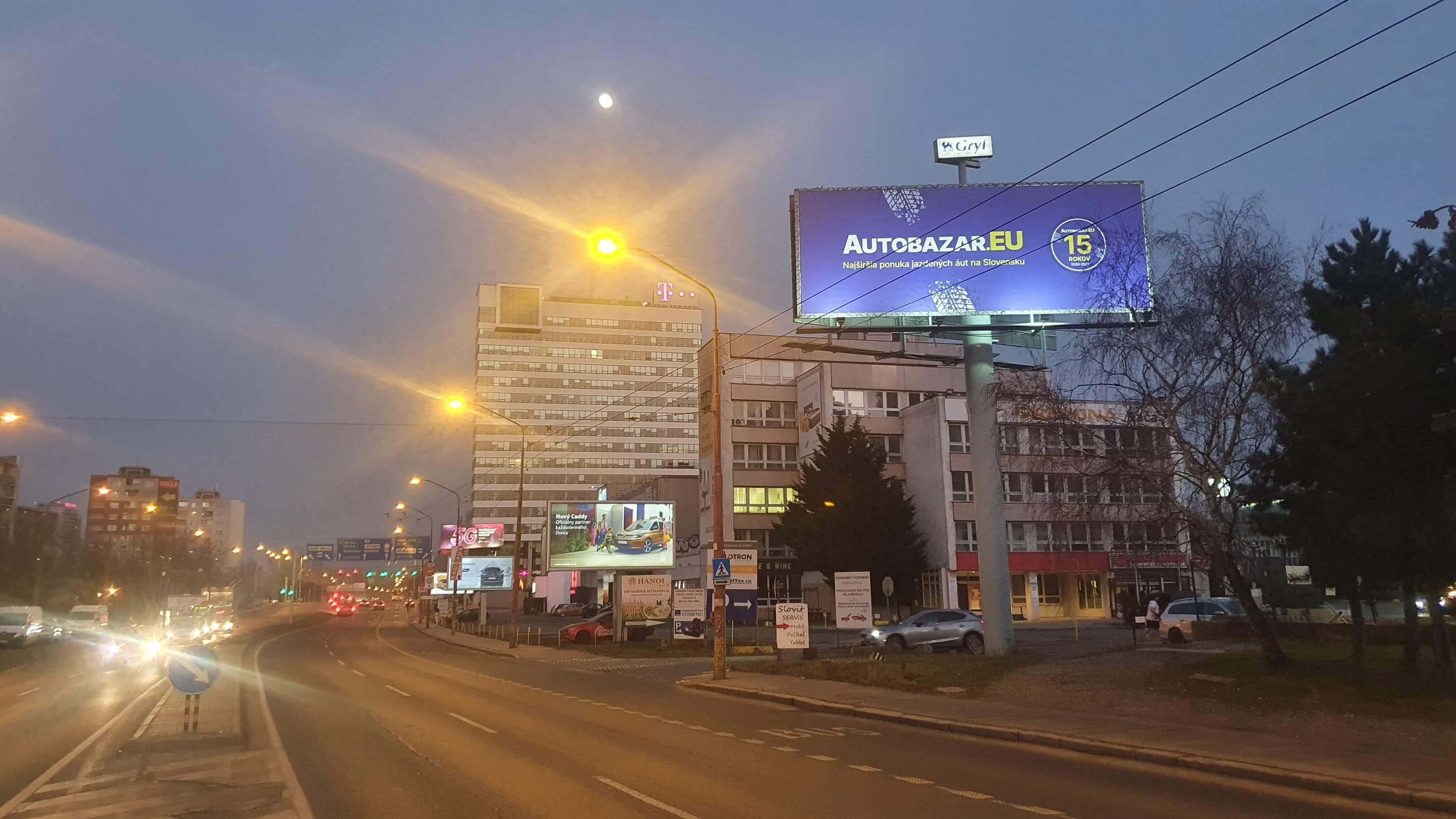 Reklamný bigboard v centre mesta so žiarivým dizajnom.