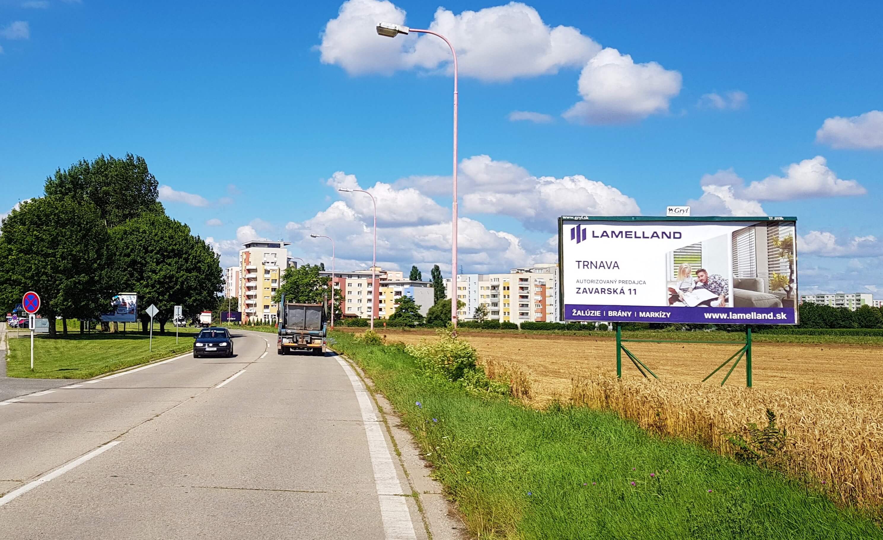 Reklamný billboard na okraji mesta pri frekventovanej ceste.